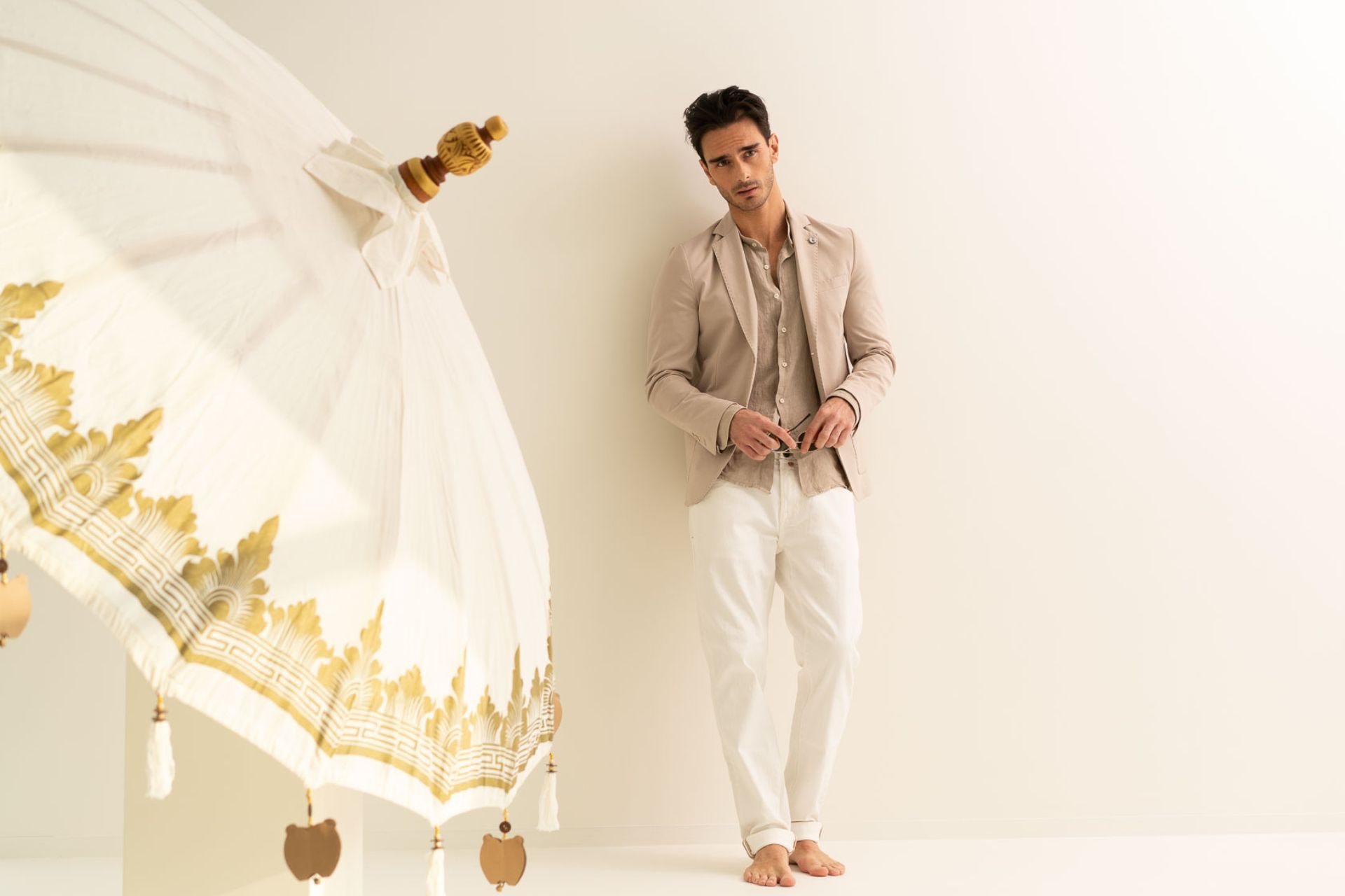 Ragazzo con outfit elegante in lino e ombrellone